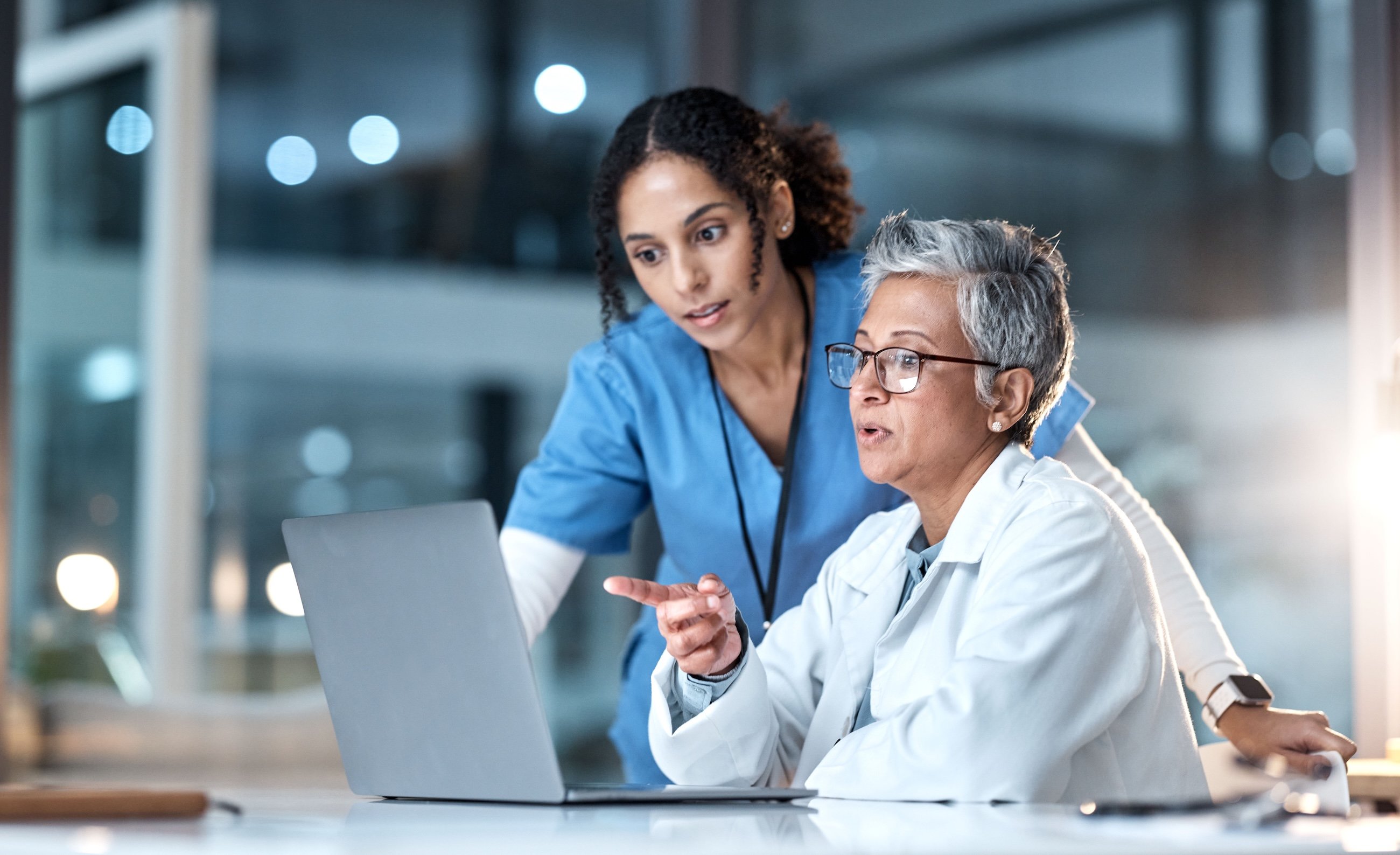 two doctors discussing the information displayed on their computer